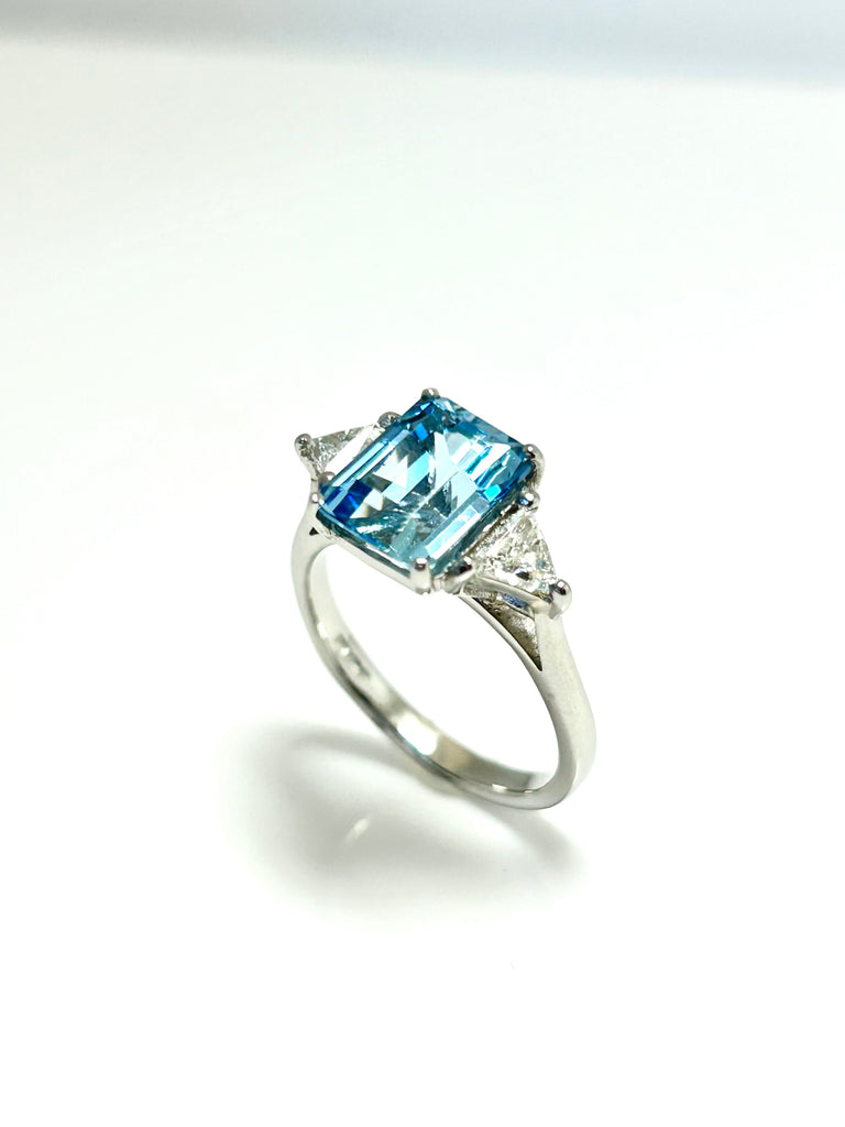 PLATINUM EMERLALD CUT AQUAMARINE AND TRILLION DIAMOND THREE STONE RING
