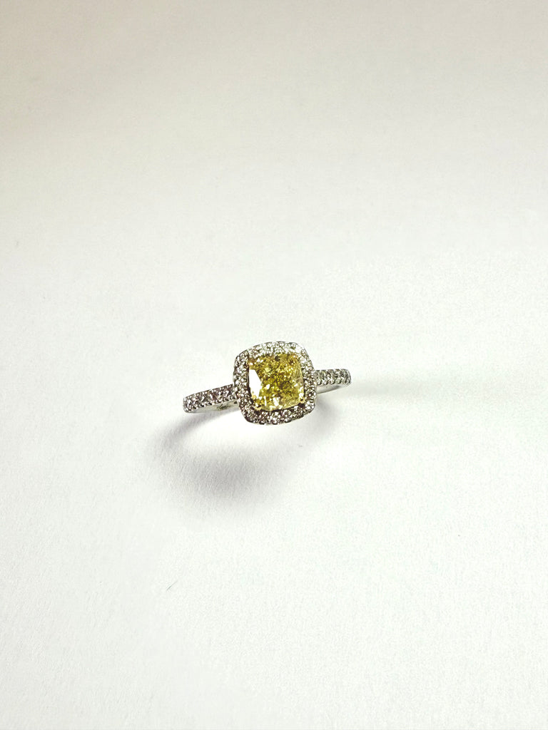 Ring with a yellow diamond and diamond accents on a white background